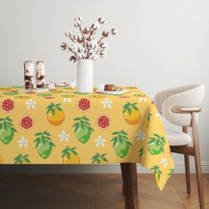 Widok rogu stołu z połacią obrusa i powtarzającym się wzorem owoców