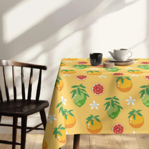 Stół nakryty obrusem z motywem cytrusów, dekoracja z kwiatami w wazonie