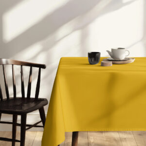 kubek i filiżanka na musztardowym obrusem o naturalnym świetle