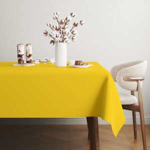 stół udekorowany żółtym obrusem z białym wazonem i przekąskami