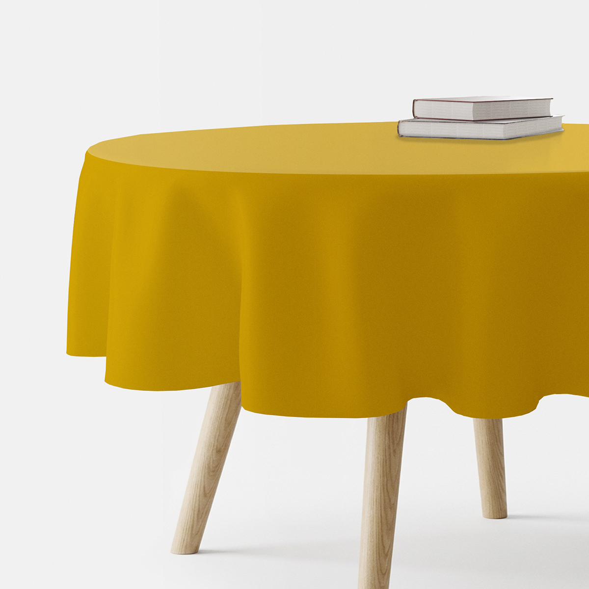 okrągły obrus w musztardowym odcieniu na stole widok z boku z książkami