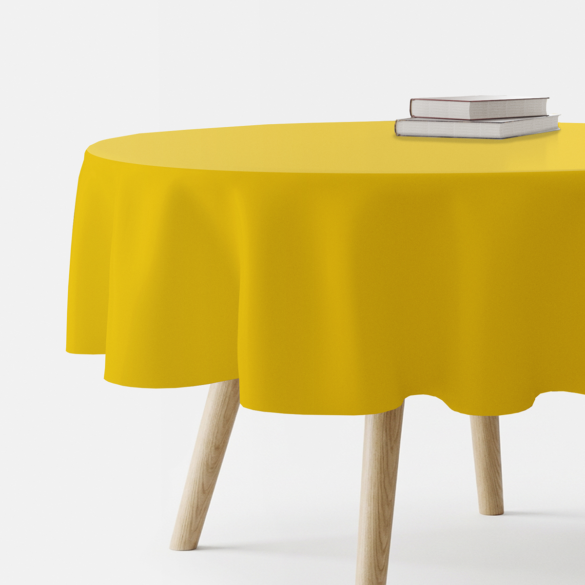 żółty okrągły obrus na drewnianym stole z dwiema książkami ułożonymi na blacie