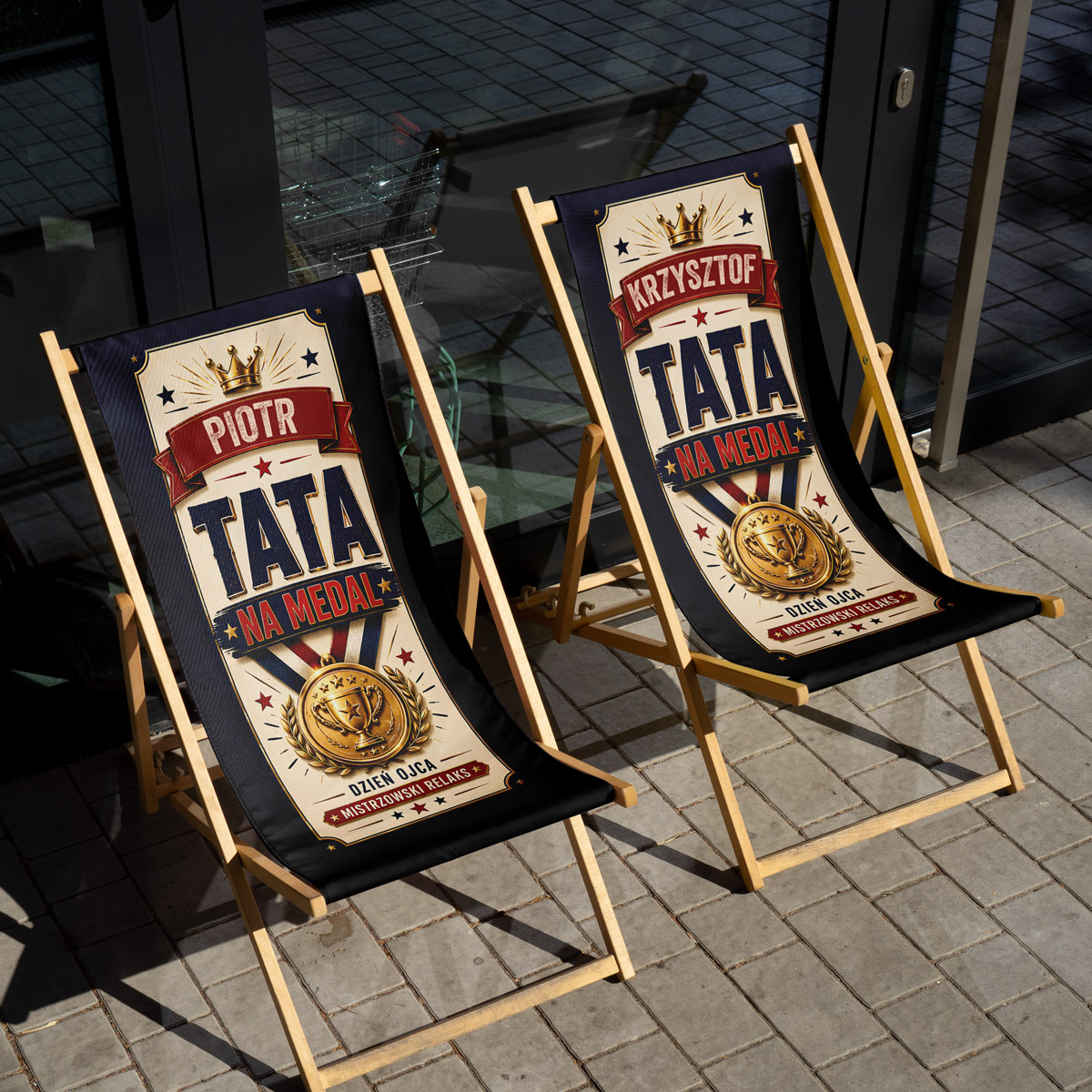 Zbliżenie na nadruk z imieniem i napisem TATA NA MEDAL na leżaku — detale złotego medalu, czerwona wstęga i retro typografia, close-up personalizacji dla taty