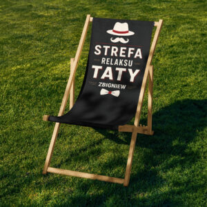 Leżak Strefa Relaksu Retro w aranżacji ogrodowej — bukowy stelaż na trawie, czarny materiał z retro nadrukiem; pomysł na prezent na Dzień Ojca i prezent dla taty